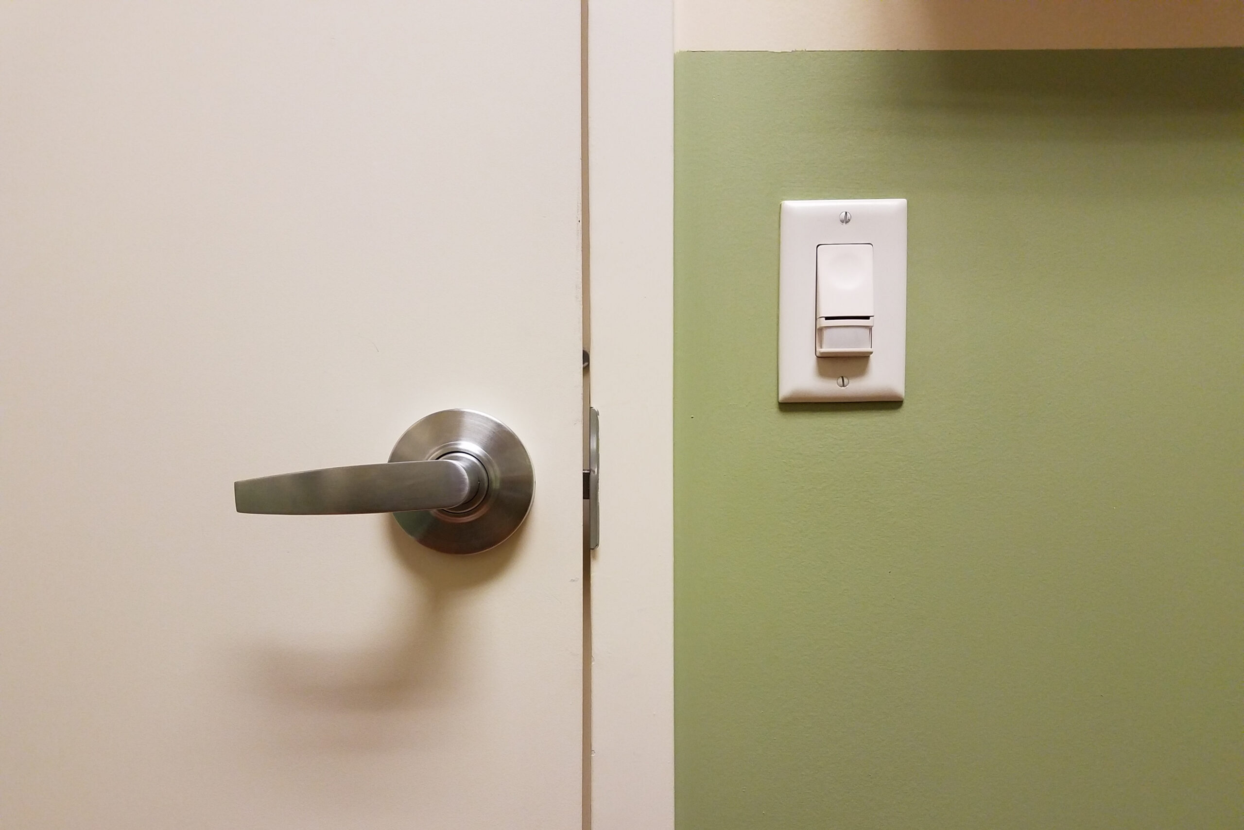 Green,Wall,With,White,Door,And,Motion,Sensor,Light,Switch