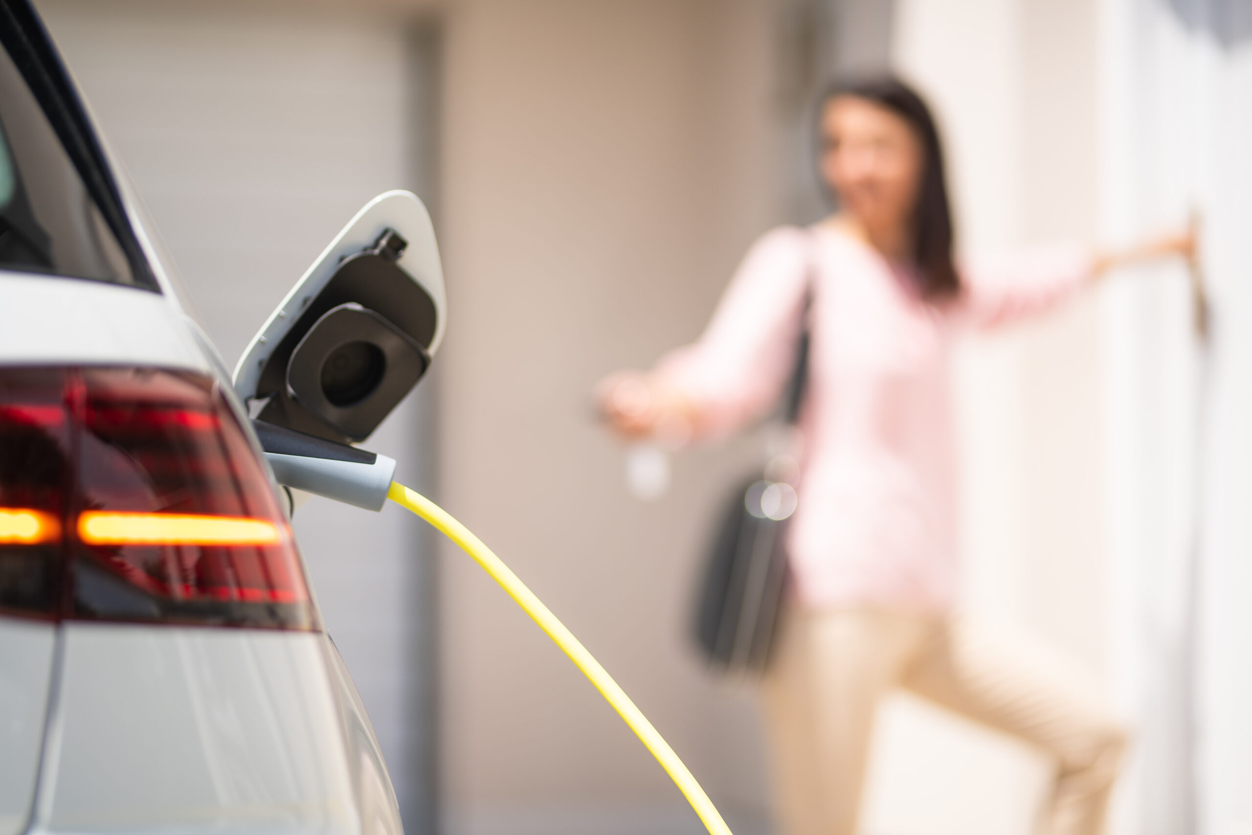 Close,Up,Of,A,Electric,Car,Charger,With,Female,Silhouette